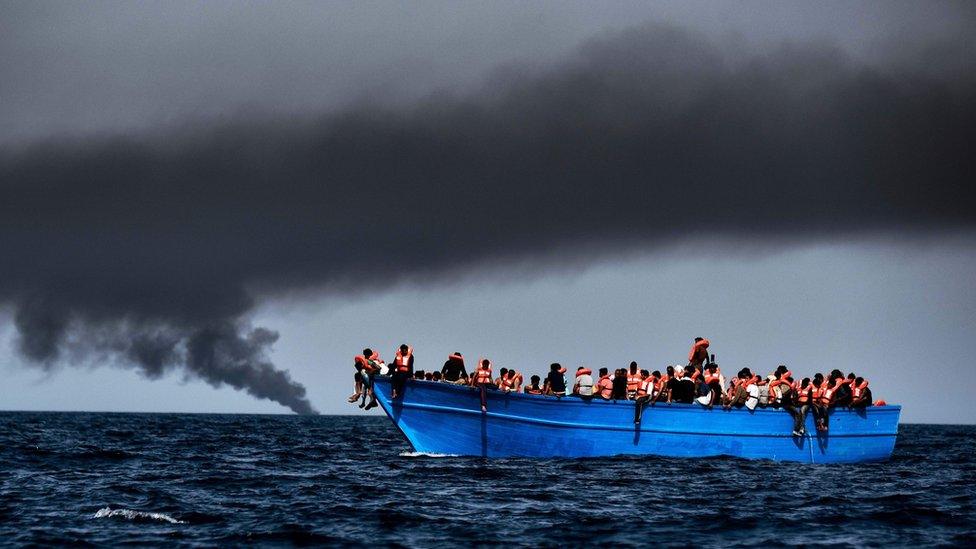 Migrants wait to be rescued as they drift at sunset in the Mediterranean Sea some 20 nautical miles north off the coast of Libya on October 3, 2016.