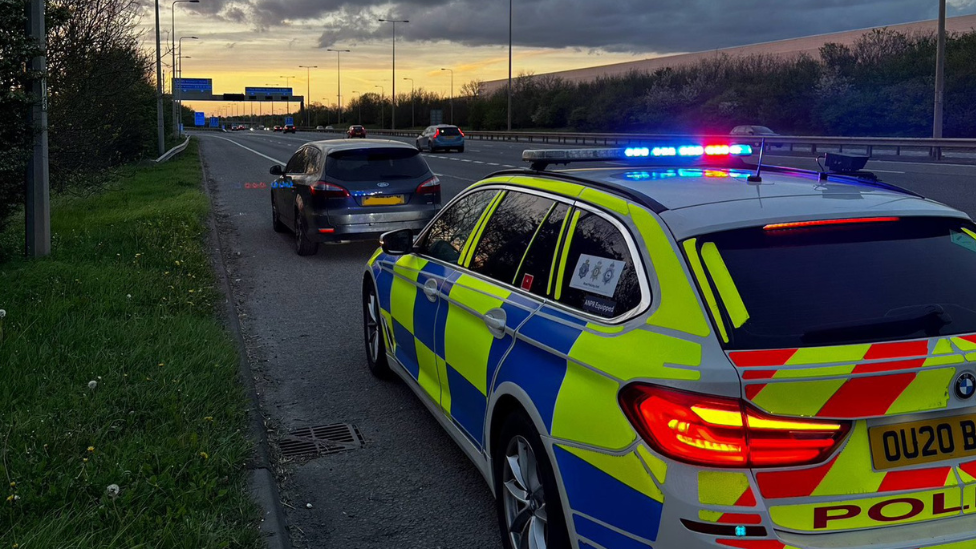 Police car stopped at the side of a road