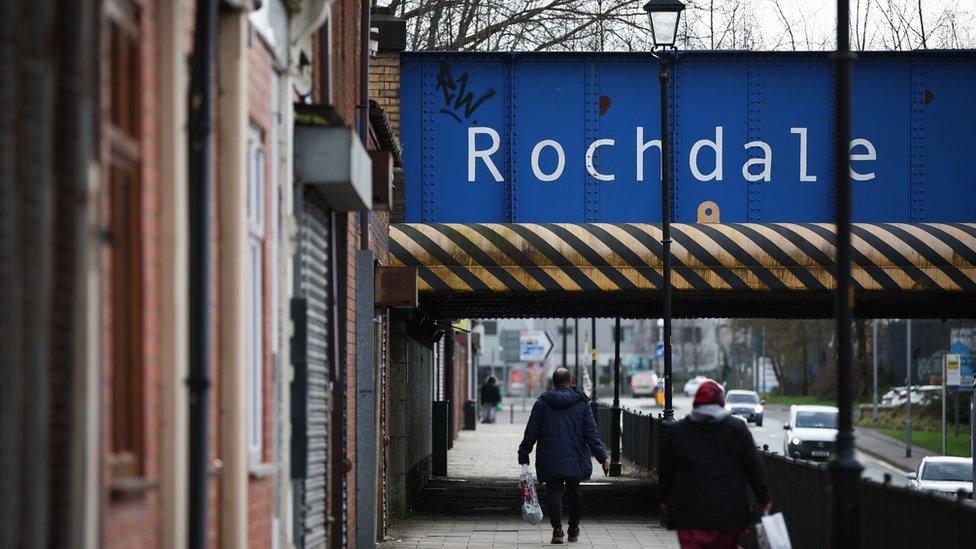 People walk along Oldham Road in Rochdale, Britain