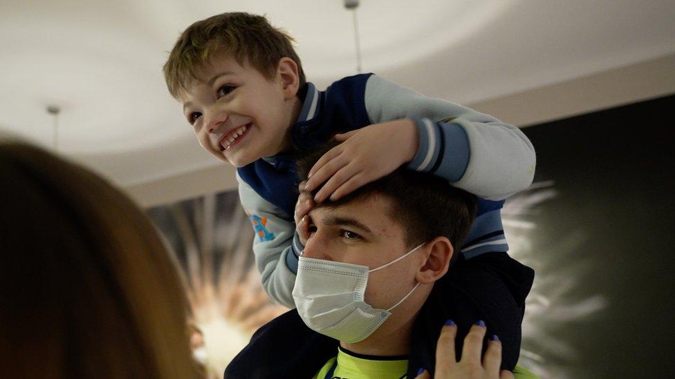 Igor, a volunteer, with Yaroslav on his shoulders