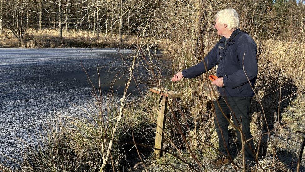 John Hart topping up one of the many bird tables with seed