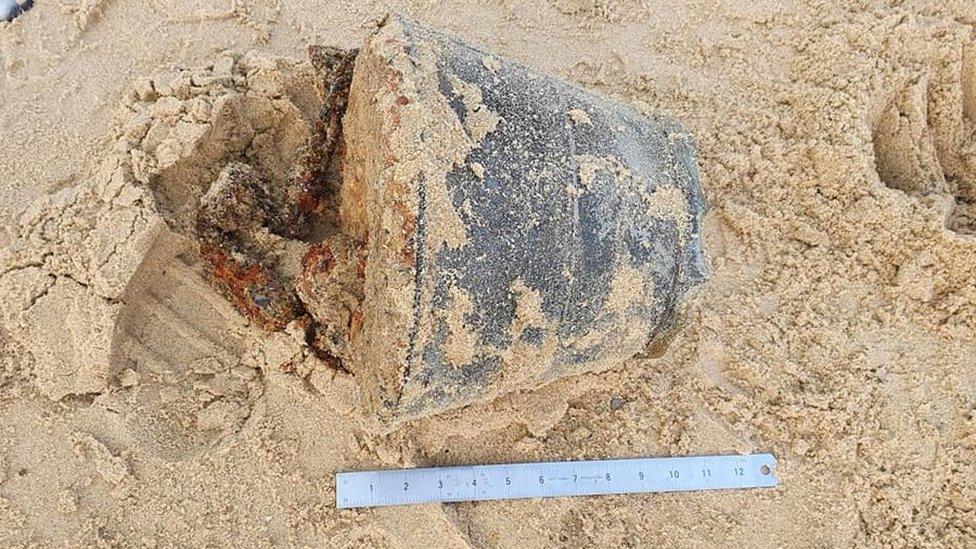 Sandy bucket on its side having been dug out of the beach