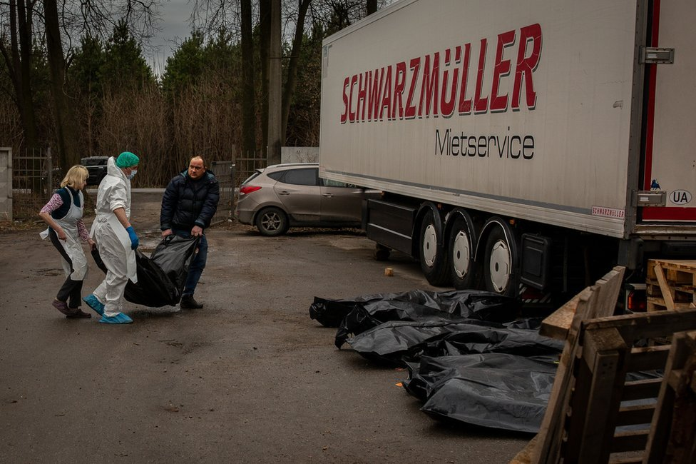 Serhiy Brezhnev helps carry Vitaliy's body bag out from the morgue, to await fingerprinting.