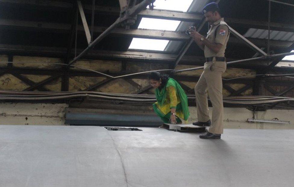 Indian police personnel stand guard alongside the Salem-Chennai Express train, which was robbed while in transit, at Egmore Railway station in Chennai on August 9, 2016. Some 50,000,000 INR, equivilent to approximately 749,000 USD, has been stolen from a moving train as it was being transported to the Reserve Bank of India, police said.