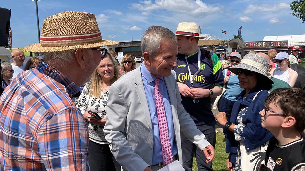 Look North presenter Peter Levy surrounded by people at the show. He is wearing a light-coloured suit with pink patterned tie and light blue shirt