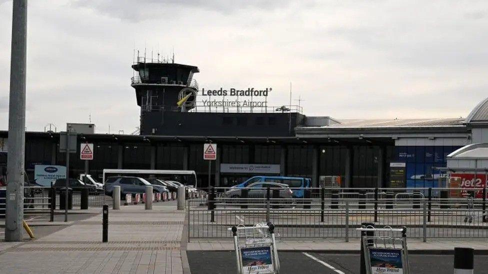 The front of Leeds Bradford Airport. A walkway dividing the road around the entrance 