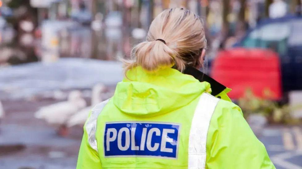 The back of a female police officer - stock photo