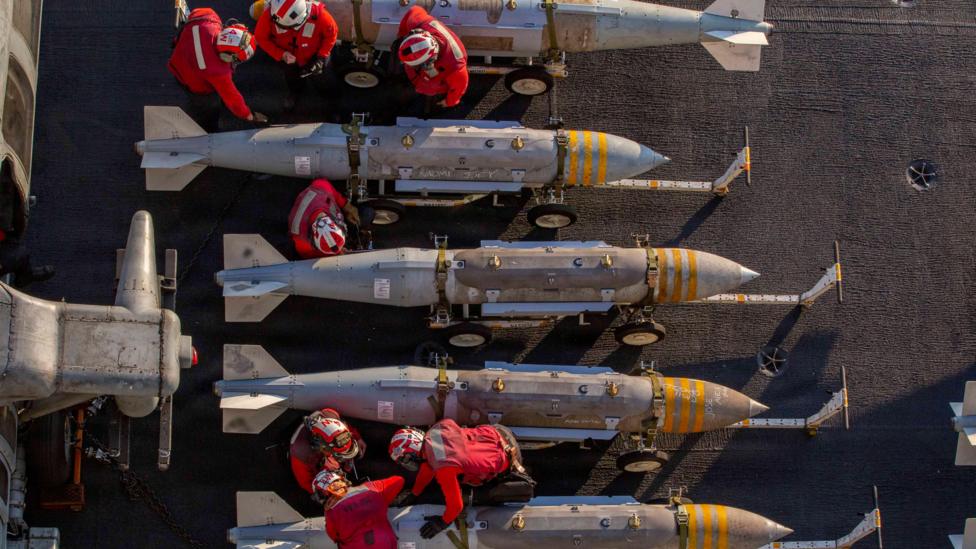 US sailors prepare to stage ordnance on the flight deck of Nimitz-class aircraft carrier USS Abraham Lincoln 