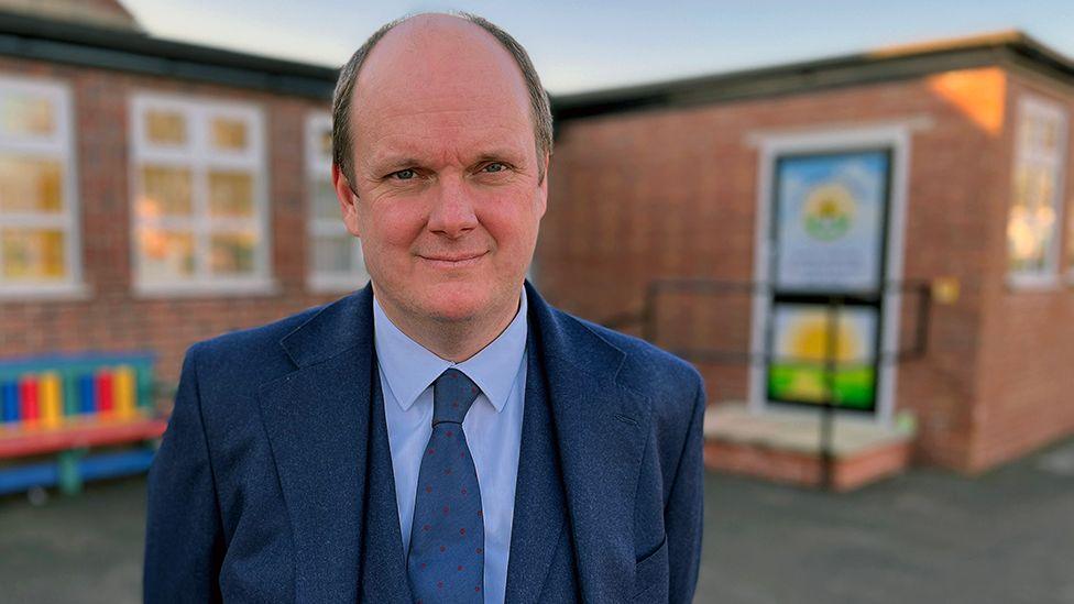 Ian Beardmore, chief executive of Newman Catholic Collegiate standing in front of a school building