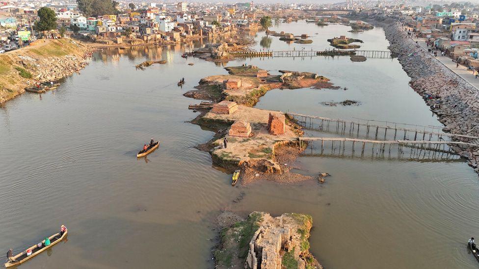 A bird's eye view of people using makeshift canoe to cross the Ikopa River, country's second-longest, on the outskirts of Antananarivo, Madagascar, 16 October 2025.