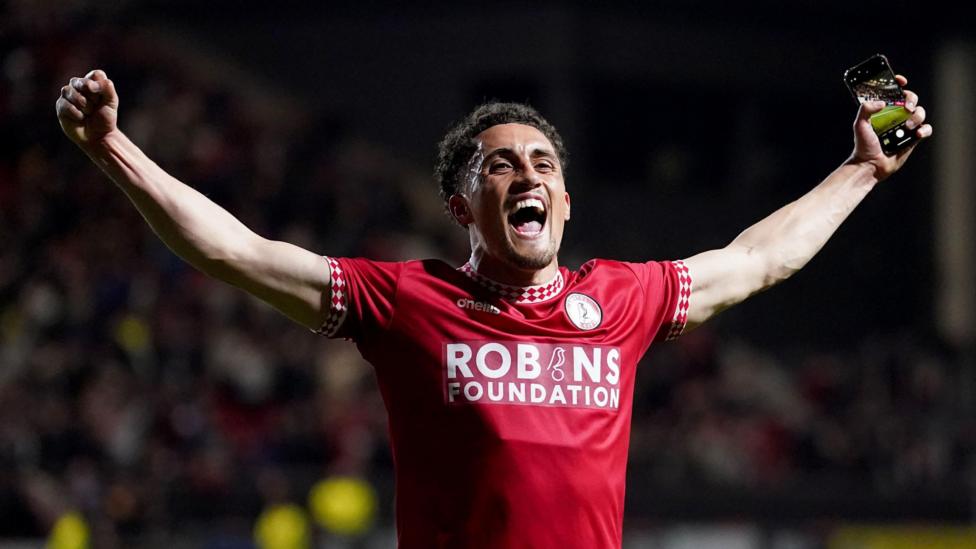 Haydon Roberts holds his arms out as he celebrates in front of Bristol City fans at Ashton Gate
