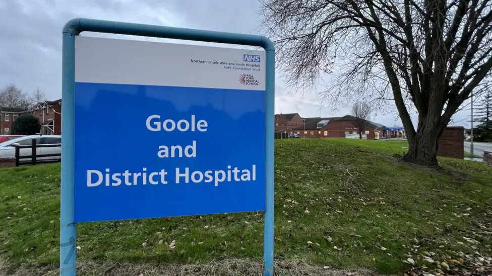 The sign outside the hospital. Goole and District Hospital is in white letters on an NHS blue background.