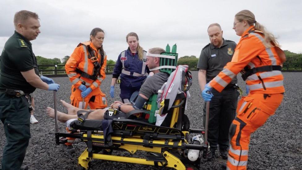 Joe Billingham being attended to by ambulance crews