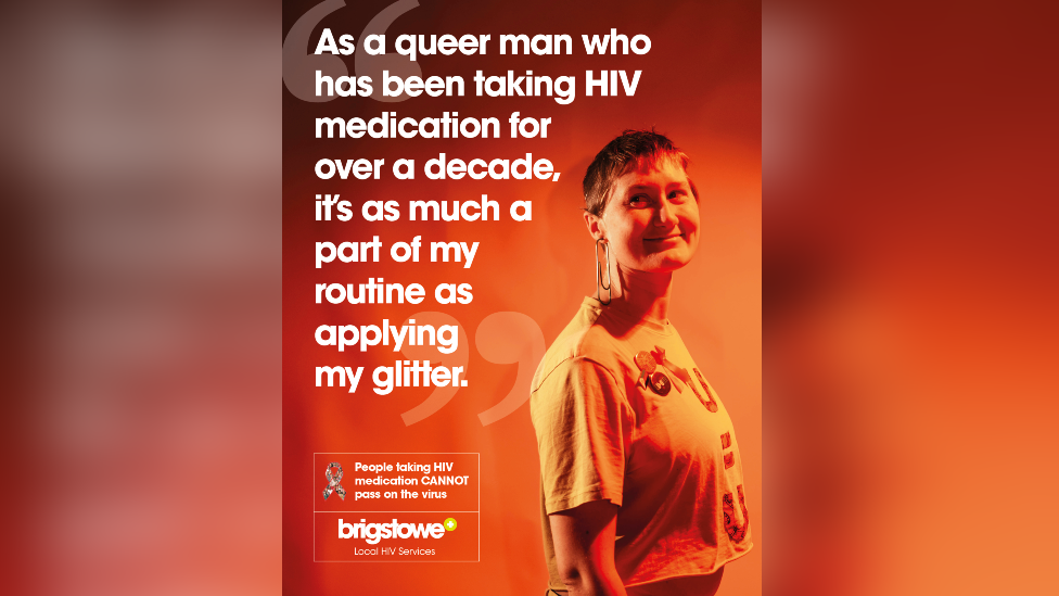 A HIV poster. A man is pictured looking at the camera and smiling. The poster is orange and red, with white text reading: "As a queer man who has been taking HIV medication for over a decade, it's as much a part of my routine as applying glitter." There is also a Brigstowe charity logo and a message to say "People taking HIV medication CANNOT pass on the virus" 