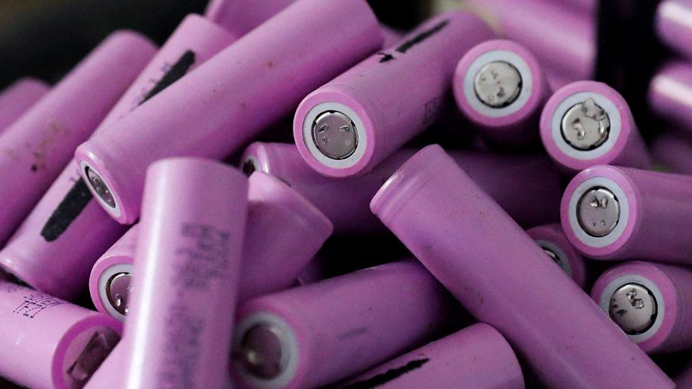 A pile of mauve-coloured, silver-ended lithium-ion batteries