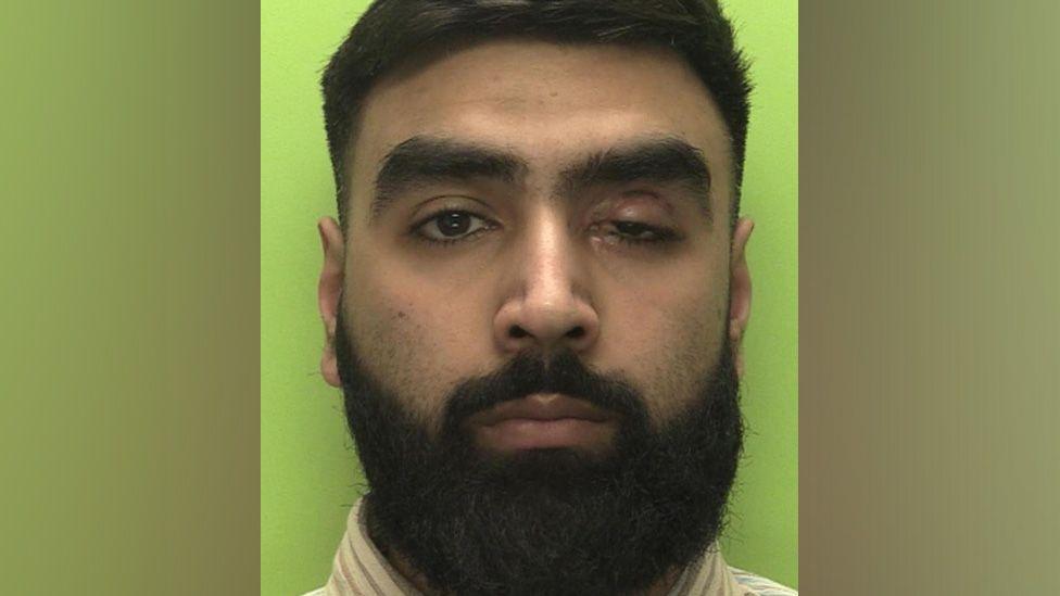 A mug shot of Haseeb Majid with a green background