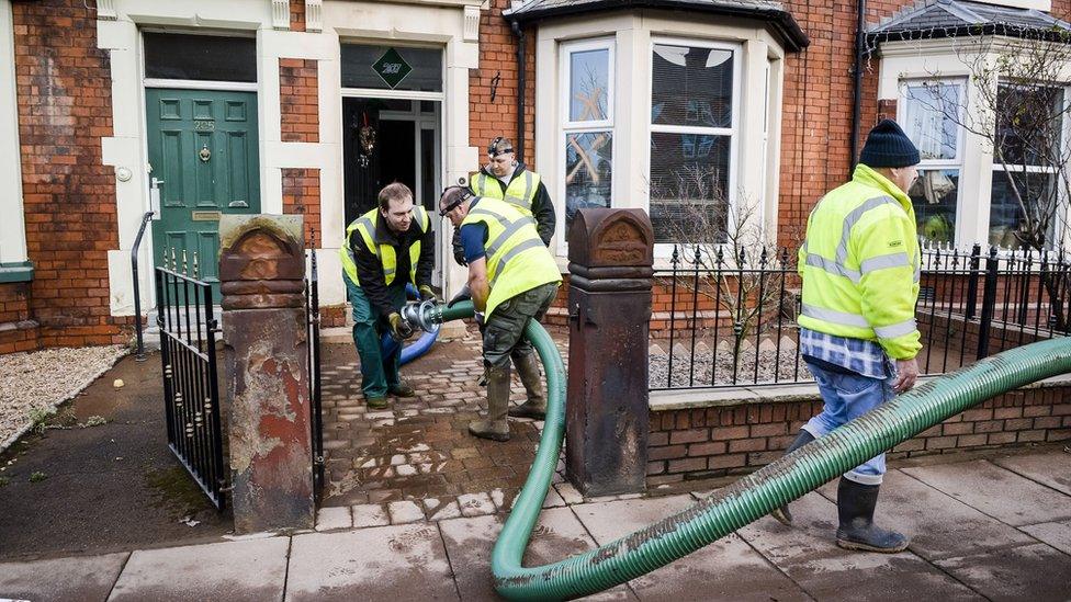 Workmen cleaning up flooded house in Carlisle