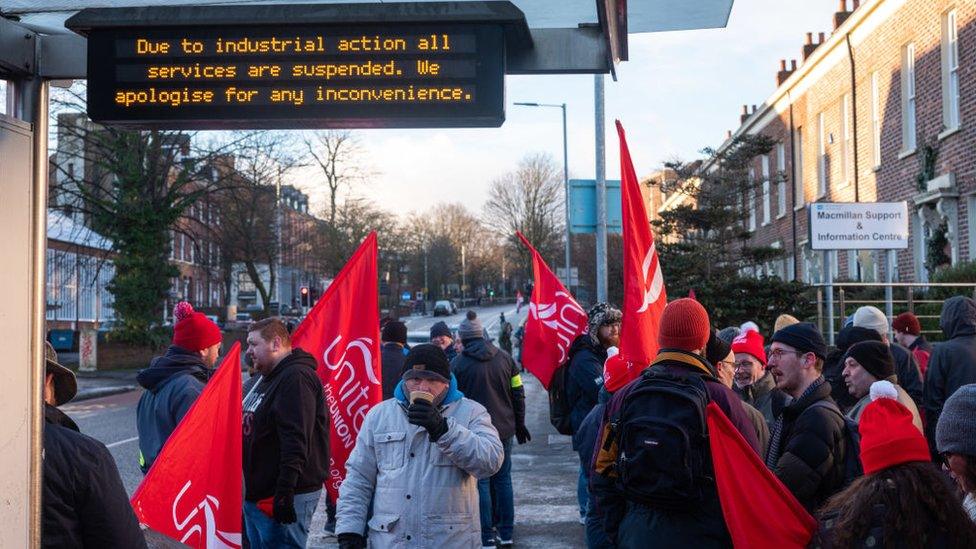 Members of the Unite Union and supporters strike on a picket line at a bus stop on the Lisburn Road in Belfast