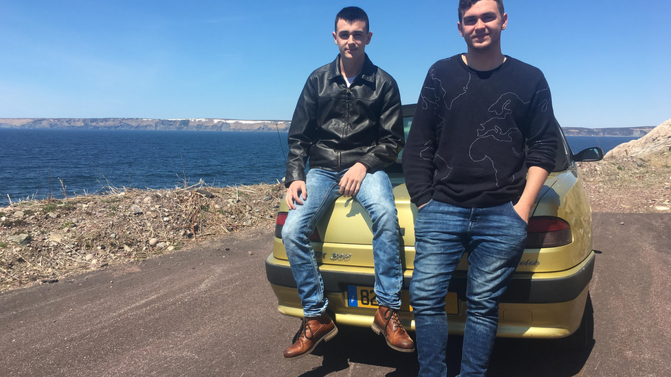 Pierre Fouchard (L) and Alex Bry (R) sitting atop Pierre's Peugeot overlooking Étang de Savoyard on Saint-Pierre island.