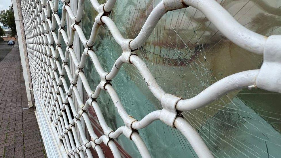 The smashed window of the office of Lee Waters and Dame Nia Griffith