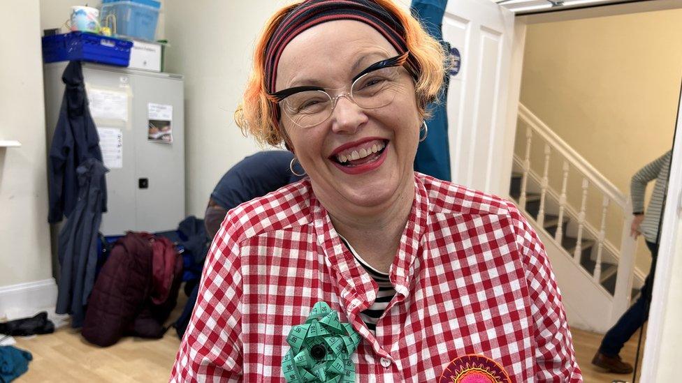 Dawn Giles, wearing a red and white checked shirt, smiling