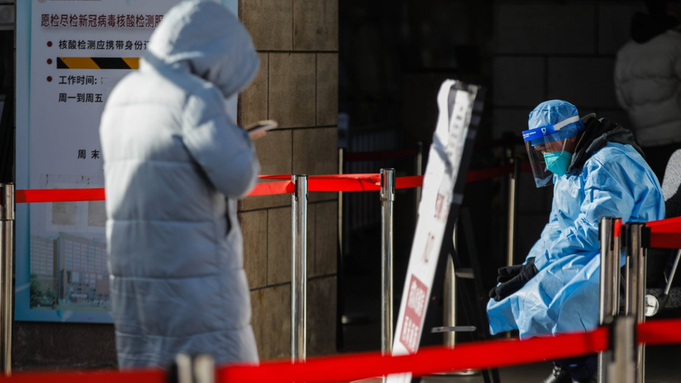 A volunteer health worker sits in front of the fever clinic at Chaoyang hospital in Beijing