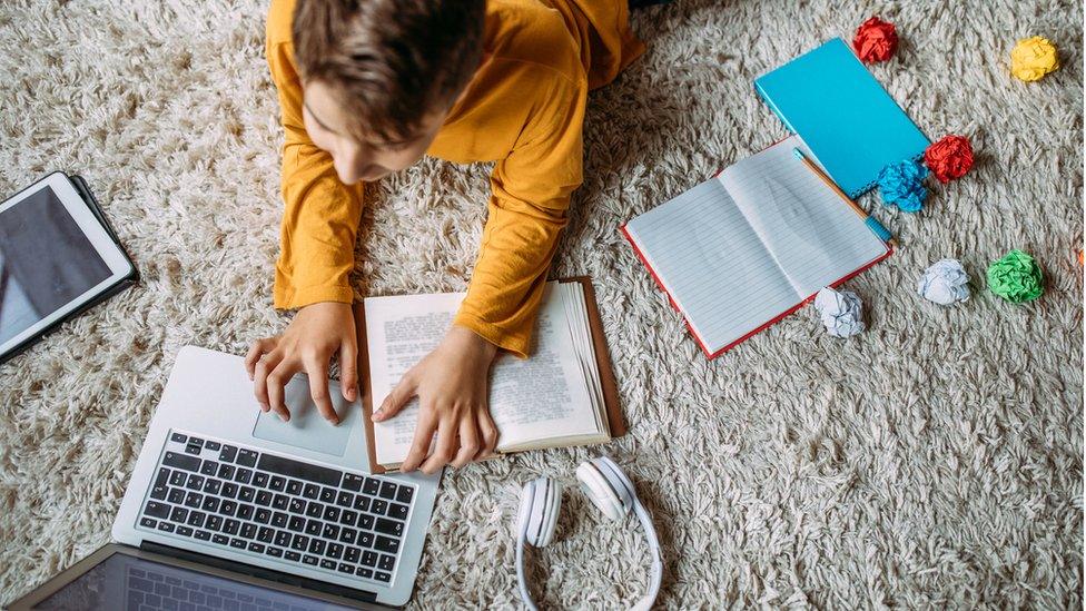 Teenager with laptop book and tablet