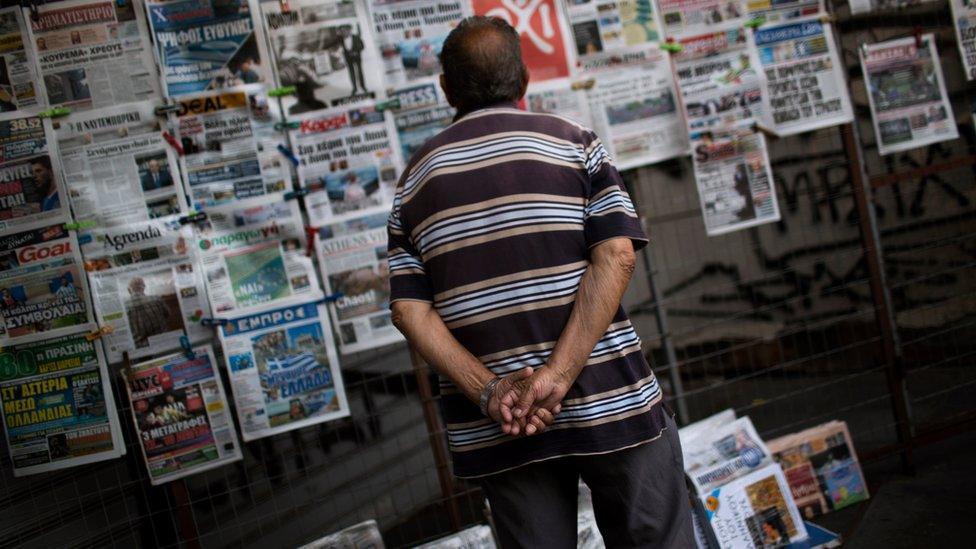 A man looking at newspapers