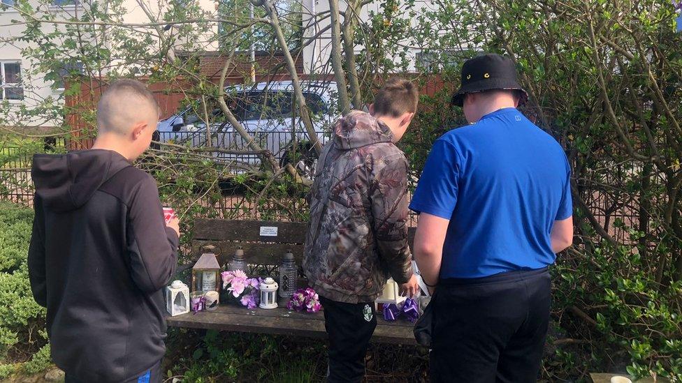 Boys looking at bench in the community garden