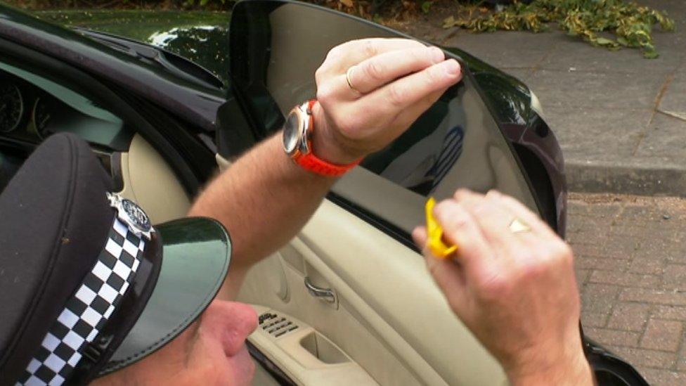 An officer removing window tints