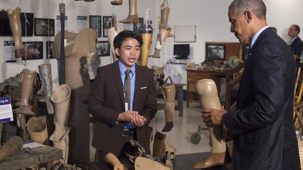 US President Barack Obama holds a prosthetic limb as he tours the Cooperative Orthotic and Prothetic Enterprise (COPE) visitor center in Vientiane on September 7, 2016