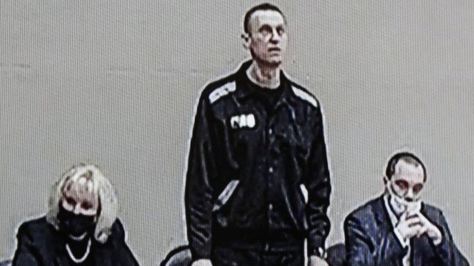 Russian opposition leader and activist Alexei Navalny (C) is seen on a screen during an offsite court session in the penal colony N2 (IK-2) in Pokrov, Vladimir region, Russia, on 15 February 2022