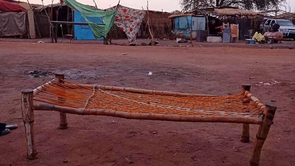 A rough bed made of string and tree branches seen on a muddy road in el-Hujairat