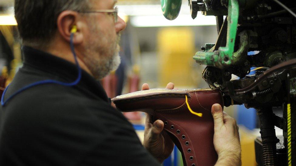 A Dr Martens employee attaches soles to boots in the Dr Martens factory in Wellingborough, Northamptonshire