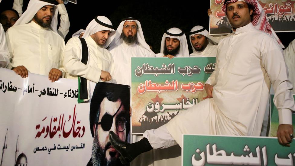 Kuwaiti protesters hold placards against Lebanese Shiite movement Hezbollah's chief Hassan Nasrallah (portrait) during a protest in front the Lebanese embassy against Hezbollah's and Iran's involvement in Syria, in Kuwait city on June 11,2013.