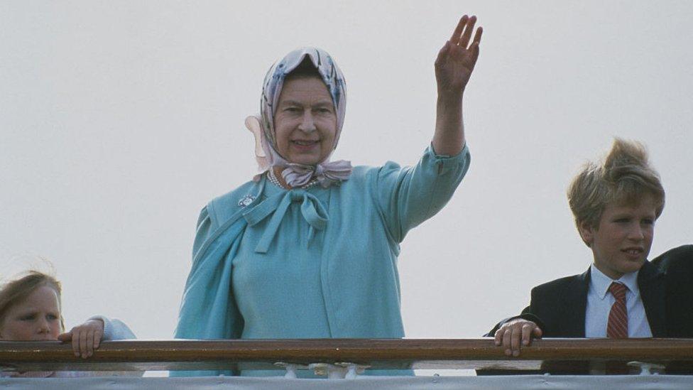 The Queen with her grandchildren Zara and Peter Phillips on board HMY Britannia, which was retired in 1997