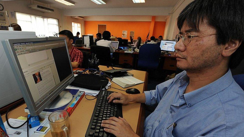 Steven Gan (R), one of the founder of a news website Malaysiakini, works on a story in his office in Kuala Lumpur on November 20, 2008.