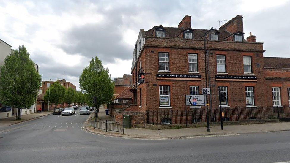 Town centre road junction with avenue flanked by trees