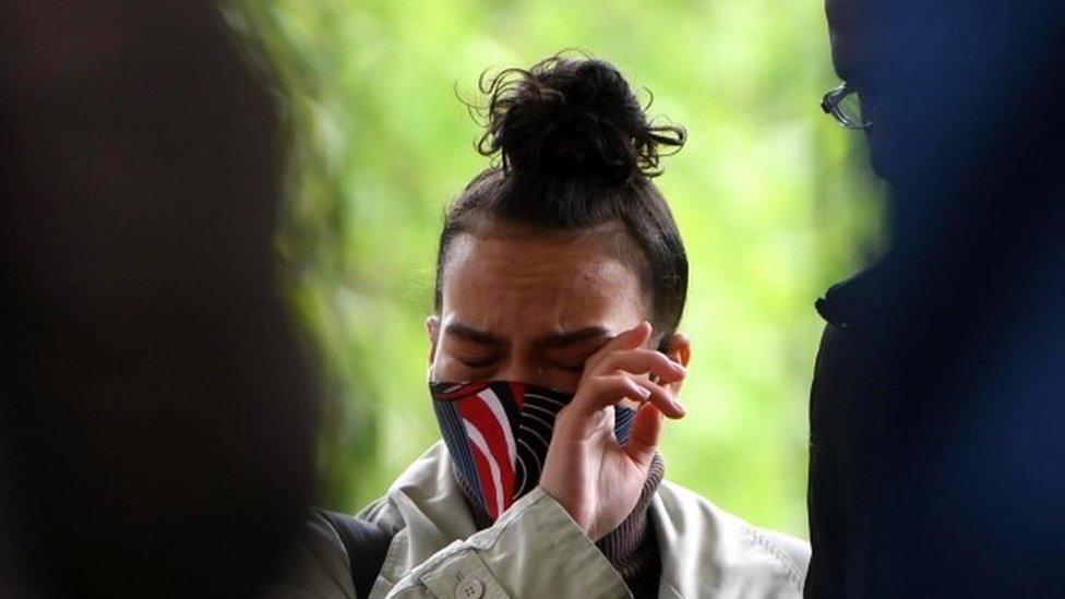 A well wisher wipes her eye as she attends a vigil for Sasha Johnson