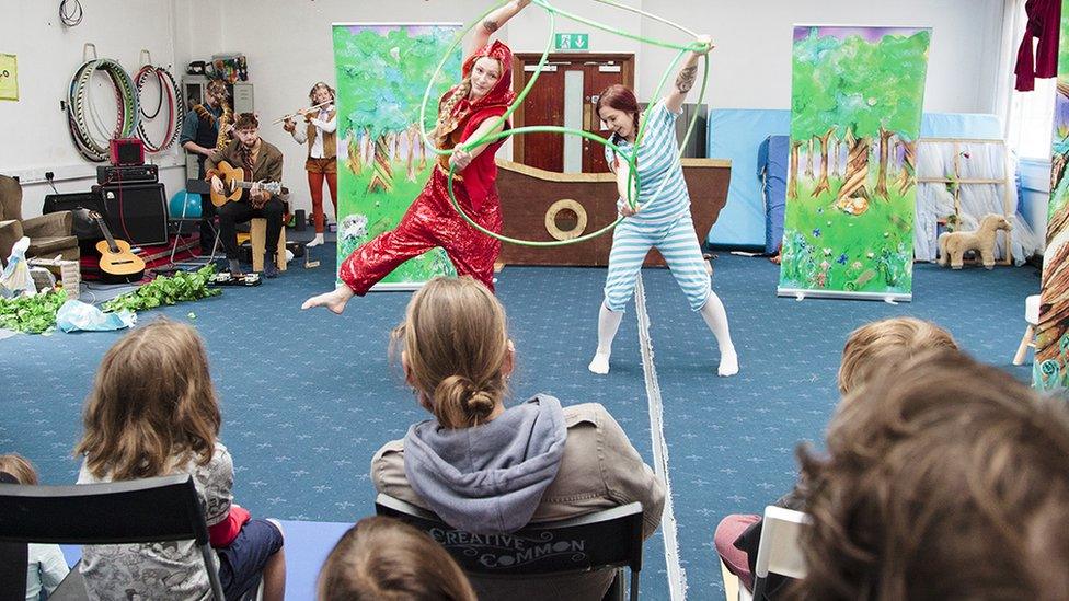 Two people doing acrobatics in front of people in a class