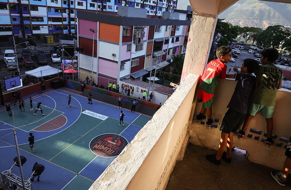 A group of children watch from a balcony during a freestyle street basketball exhibition as part of the Court Kingz: World Tour in Caracas, Venezuela. Photo by Jesus Varga