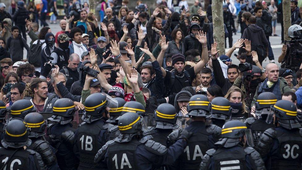 Protesters raise their hands as French Riot Police advance