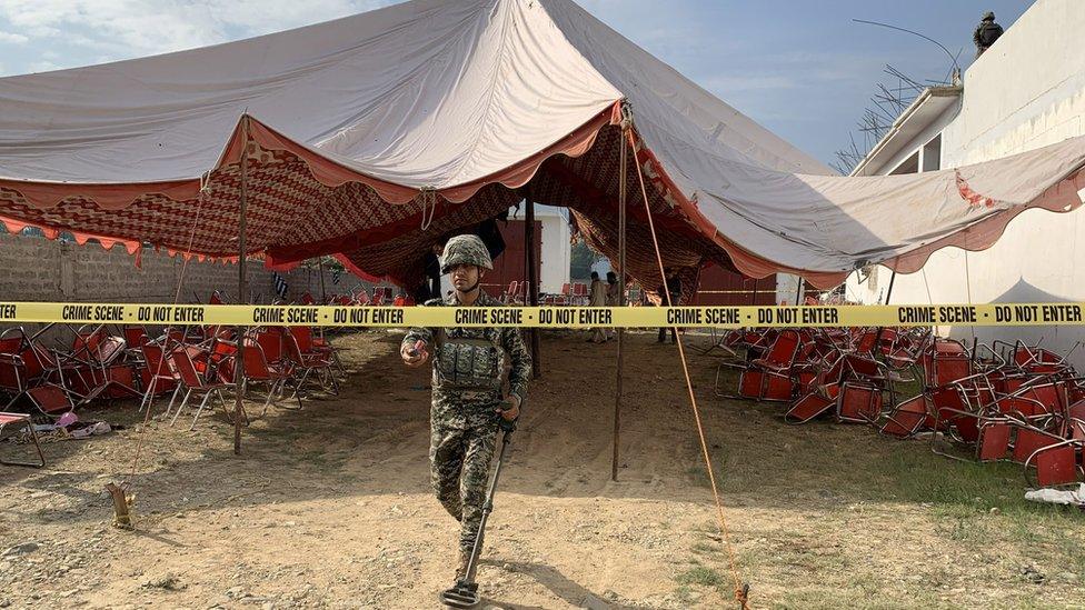 Security officials inspect the scene of a bomb explosion in Khar, Bajaur district, Pakistan, 31 July 2023.