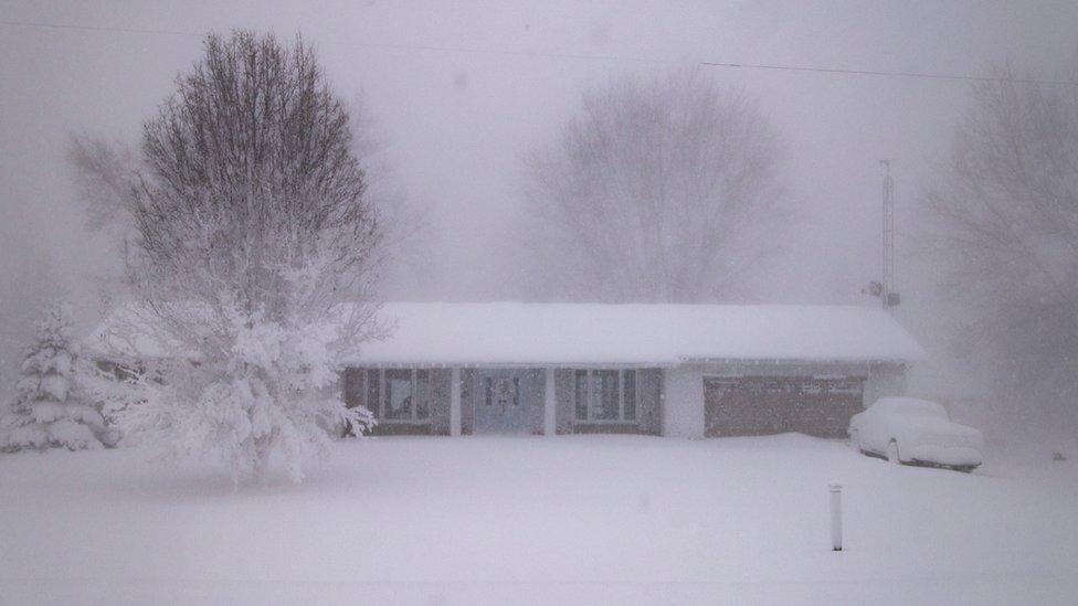 A snow-covered house and a car in Ontario, Canada