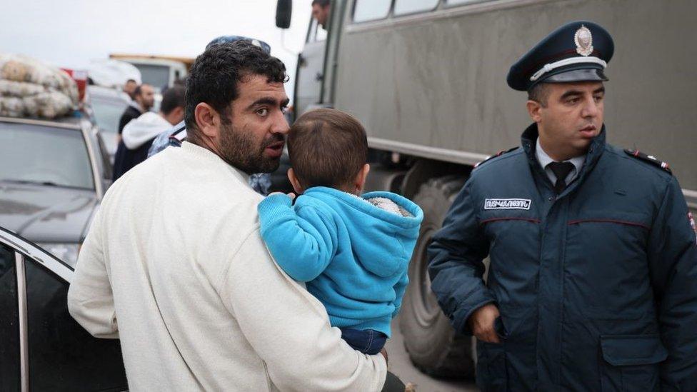 A man and his son crossing the border at a registration centre of the Armenian foreign affairs ministry, near the border town of Kornidzor