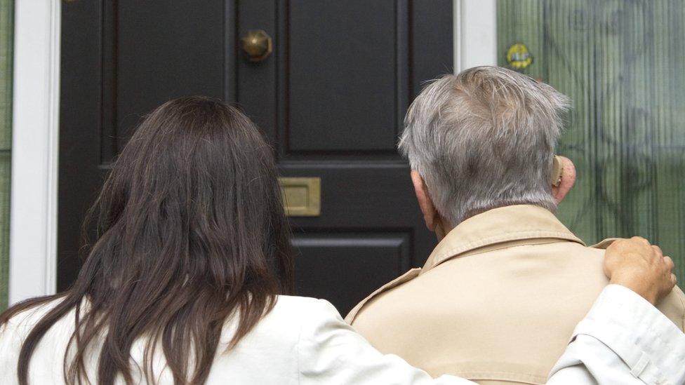 elderly man outside a house