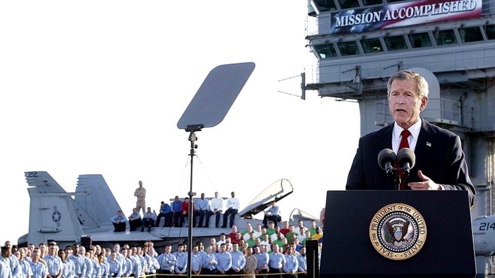 George W Bush with the banner on the aircraft carrier USS Abraham Lincoln in May 2003