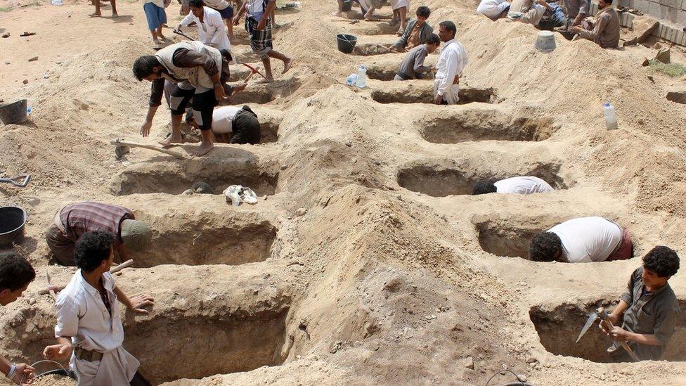 Yemenis dig graves for children in the wake of an air strike on a bus in Saada province