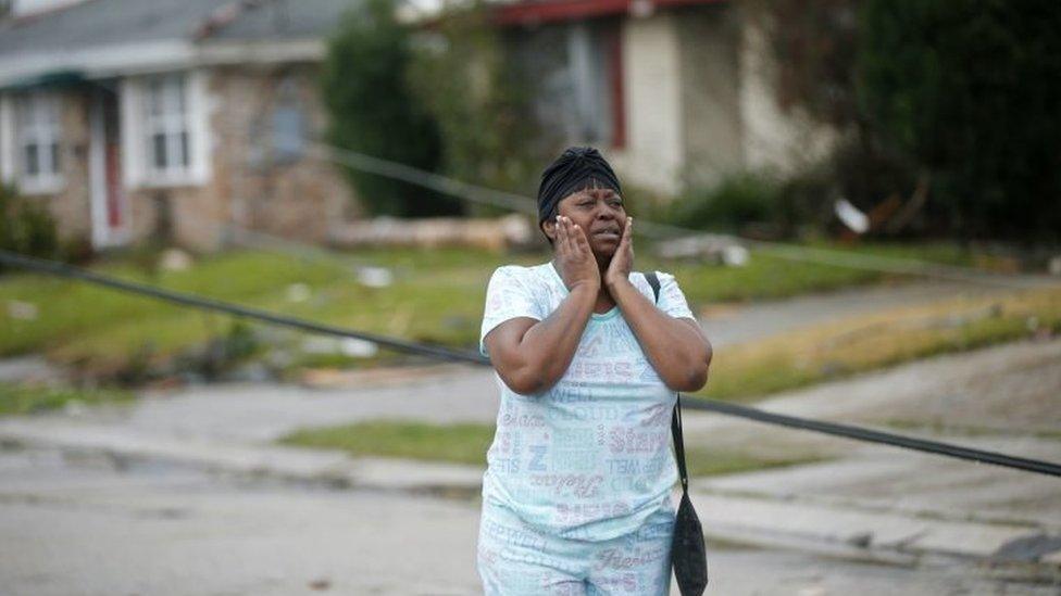 A woman looks at the wreckage caused by a tornado in New Orleans, Louisiana.