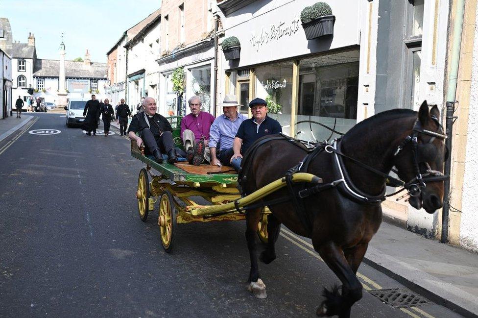 Archbishop of York Stephen Cottrell rides on a horse-drawn carriage as he is shown around the annual Appleby Horse Fair on Friday